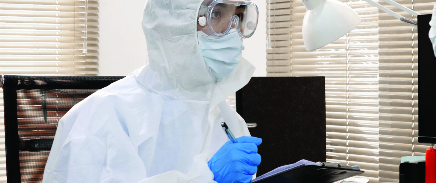 Scientist in hazmat suit holding clipboard