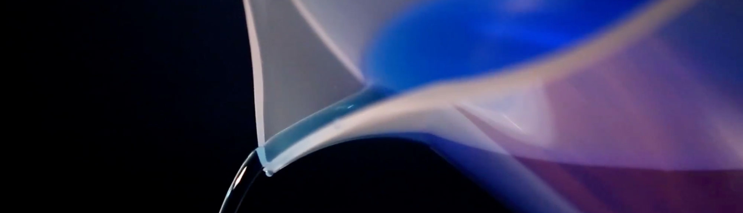 Close up of measuring cup pouring blue liquid