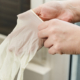 Close Up of Person Putting On Disposable Gloves