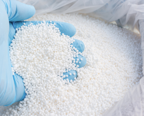 Close-up of fertilizer with blue-gloved hand dipping into it