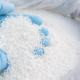 Close-up of fertilizer with blue-gloved hand dipping into it