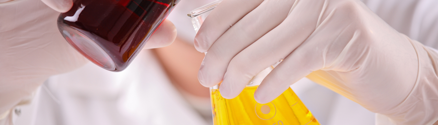 Close-up of hands mixing chemicals in a beaker