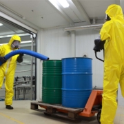 Two professionals working with toxic waste in factory